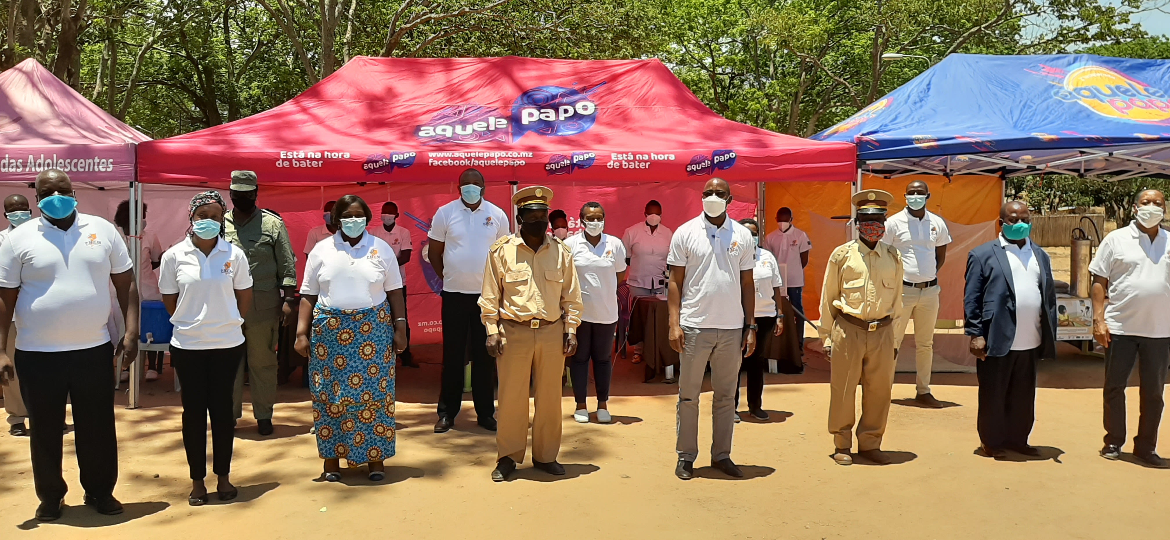 Group of people wearing face masks stand in rows looking at camera
