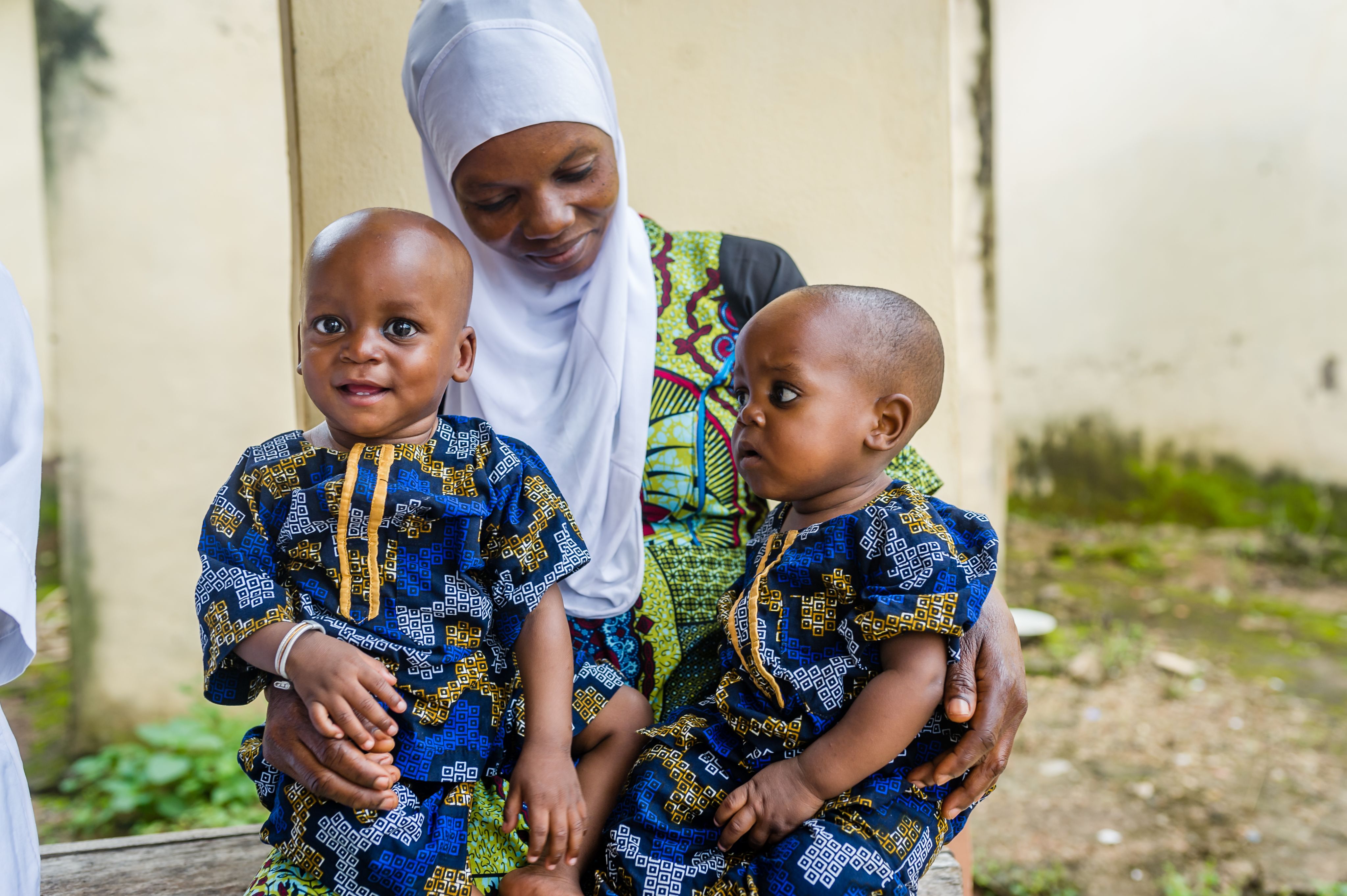 Mother holds two young children in her arms