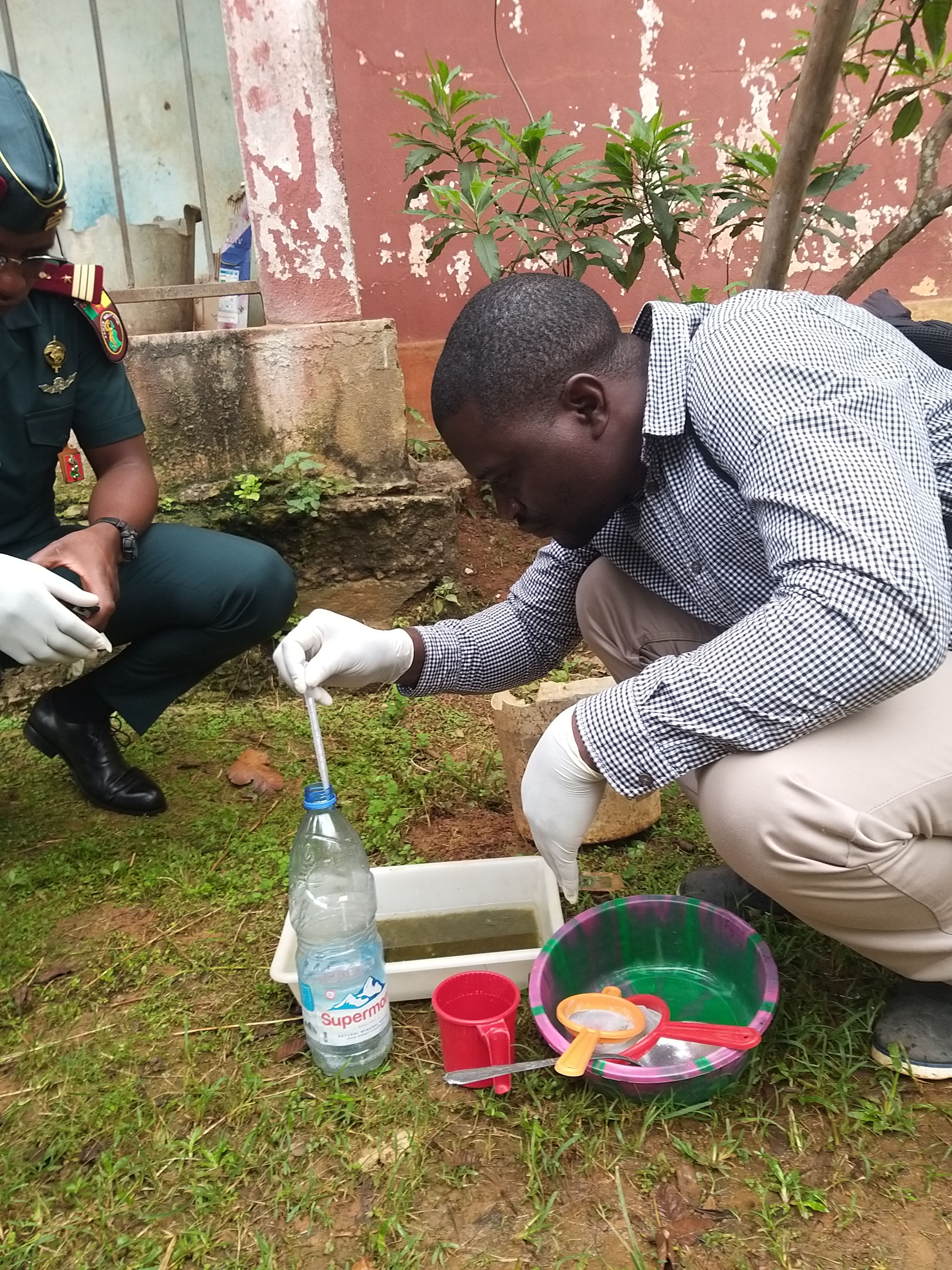 Man crouching to look at water containers
