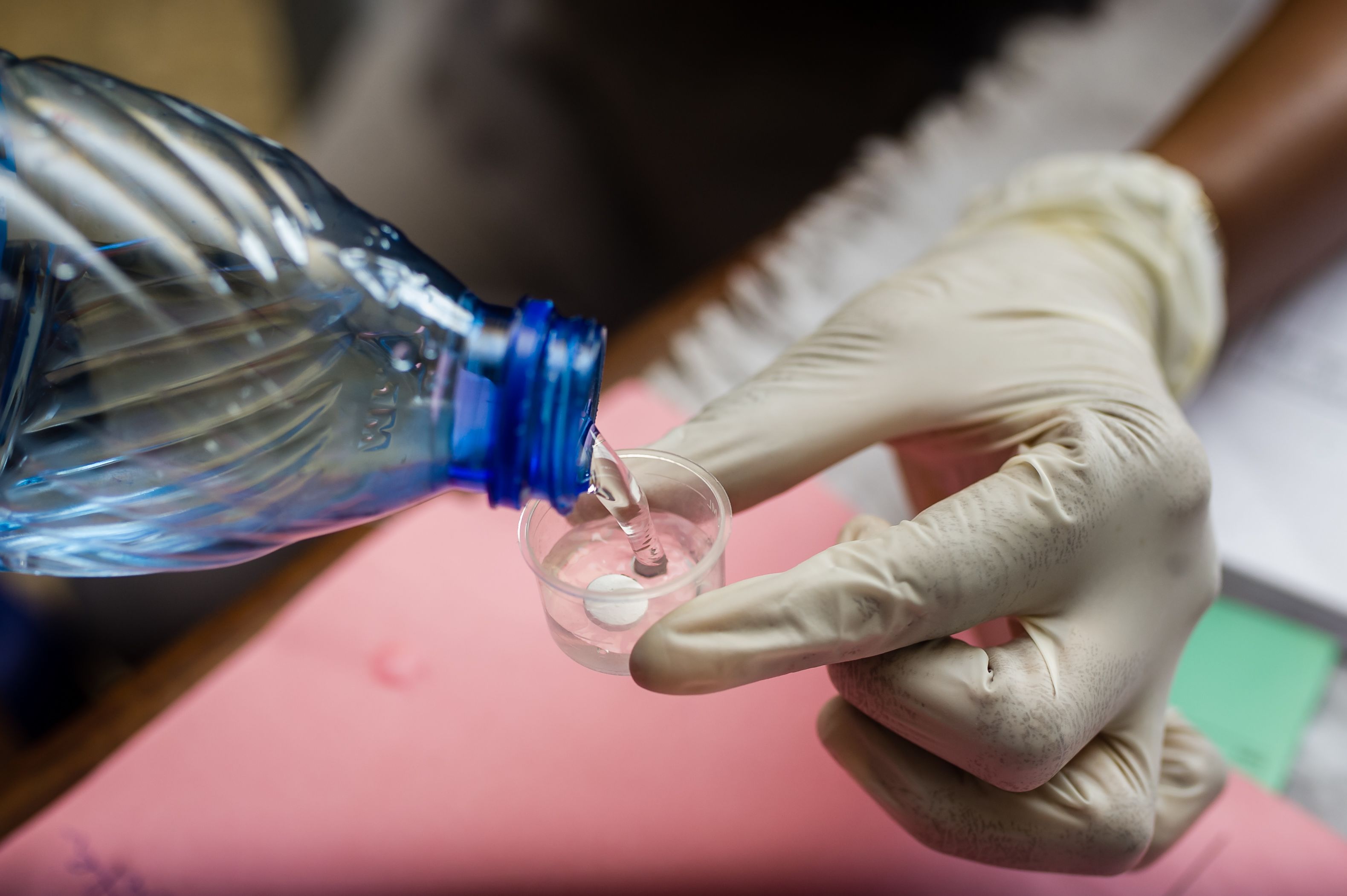 Water is poured into a small cup containing a tablet