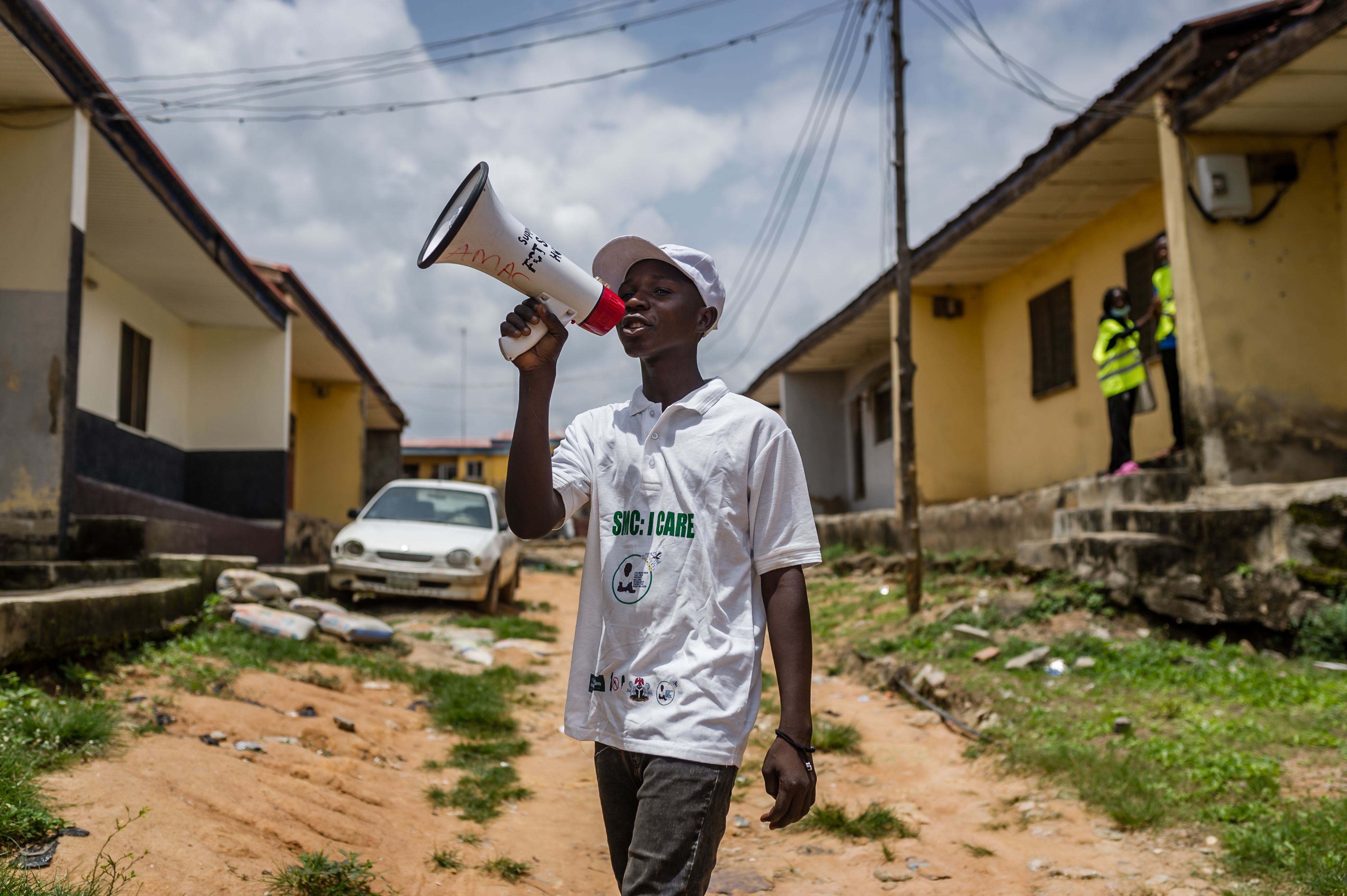 Boy talks through megaphone as he walks along the street