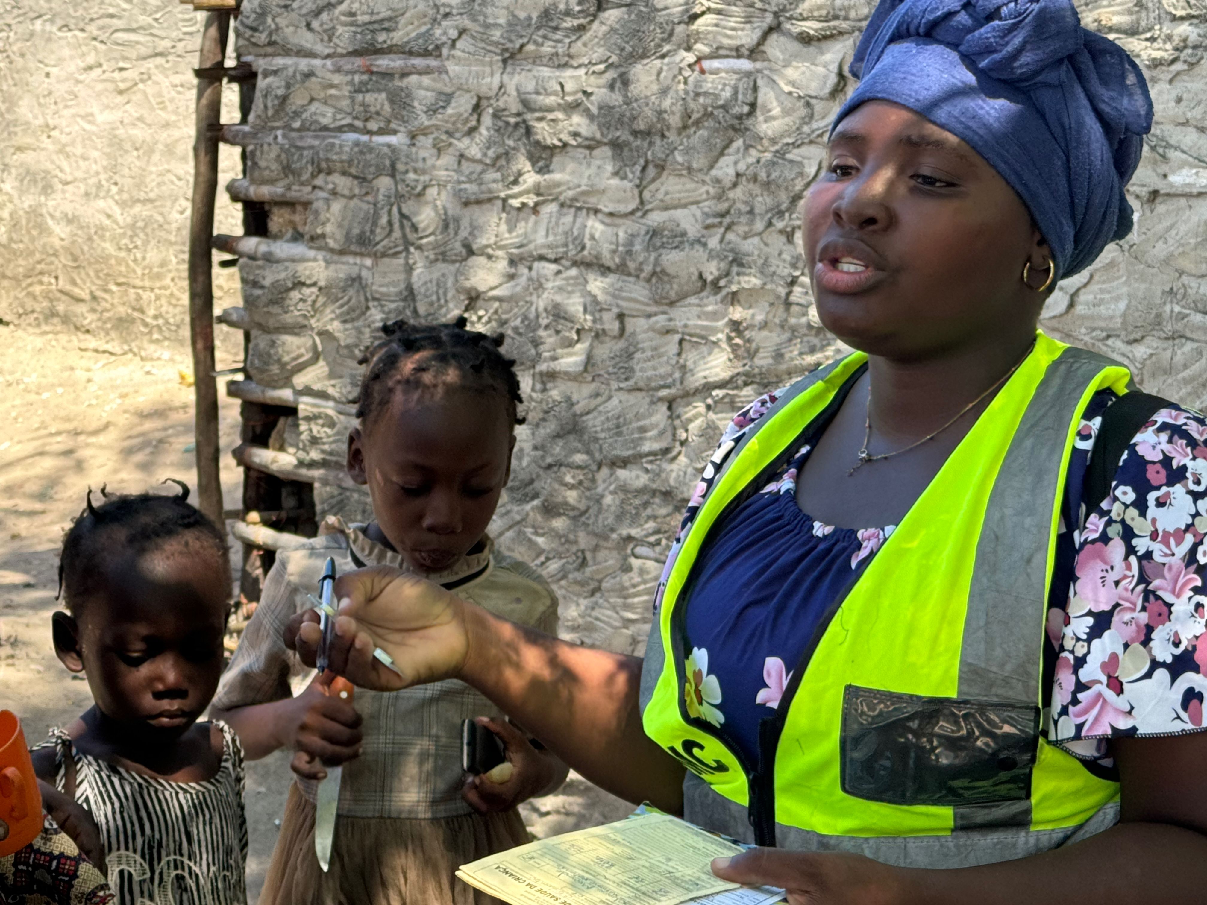 Woman standing beside two children holding paperwork