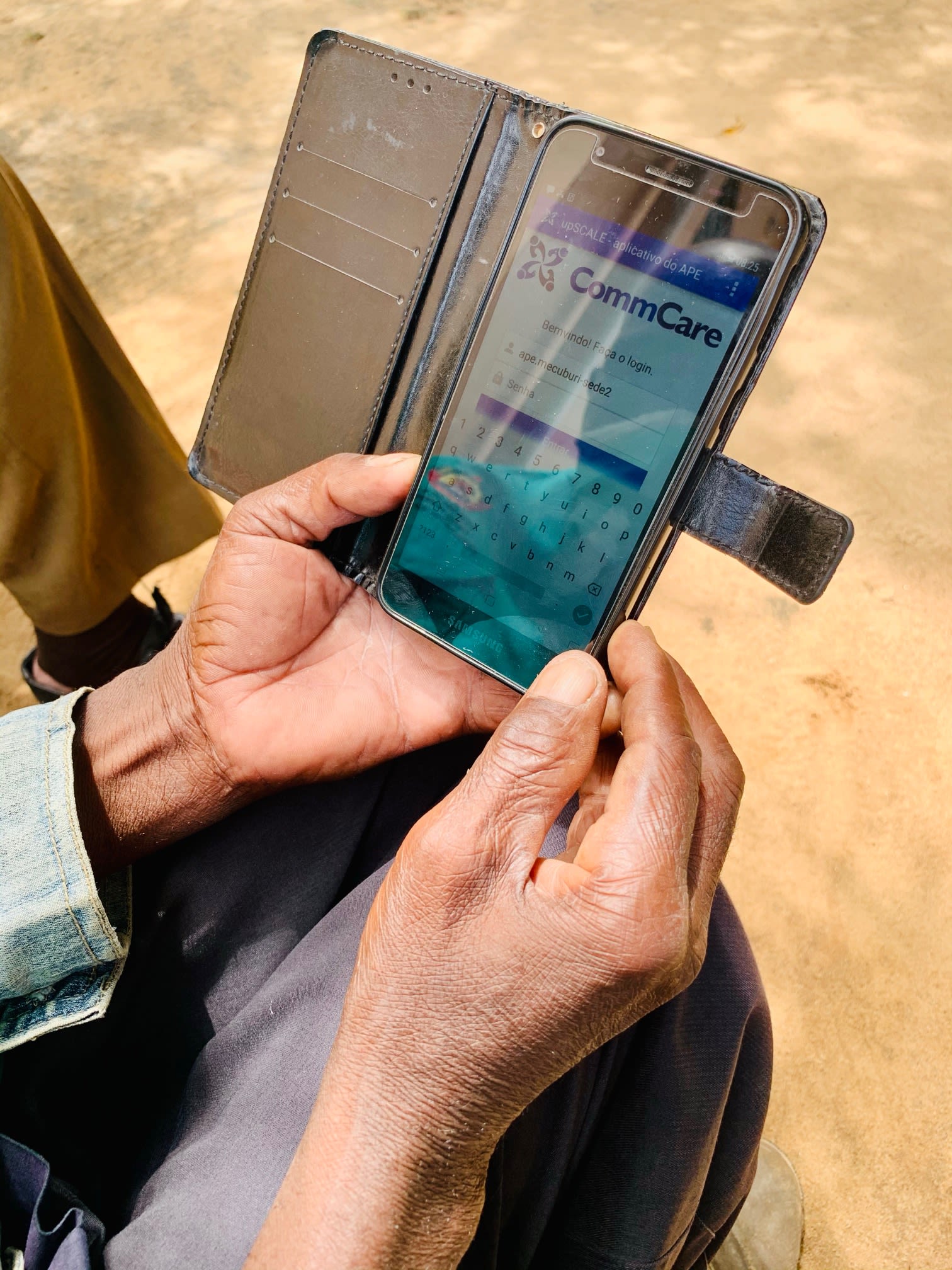 Hands holding mobile device with the CommCare app showing onscreen